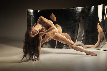 Image showing Young and stylish modern ballet dancer on brown background