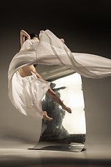 Image showing Young and stylish modern ballet dancer on brown background