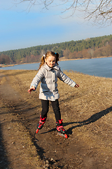 Image showing young girl goes in roller skates on the ground