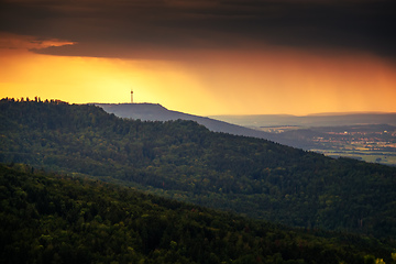 Image showing dramatic stormy sky evening light over forest and radio tower