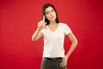 Image showing Caucasian young woman\'s half-length portrait on red background