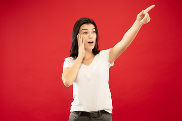 Image showing Caucasian young woman\'s half-length portrait on red background