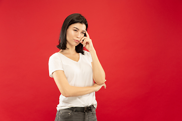 Image showing Caucasian young woman\'s half-length portrait on red background
