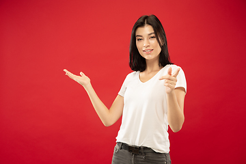 Image showing Caucasian young woman\'s half-length portrait on red background