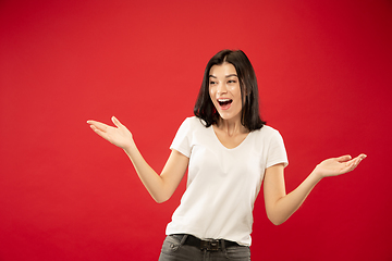 Image showing Caucasian young woman\'s half-length portrait on red background