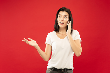 Image showing Caucasian young woman\'s half-length portrait on red background