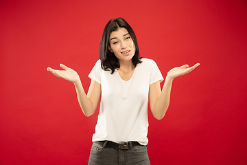 Image showing Caucasian young woman\'s half-length portrait on red background