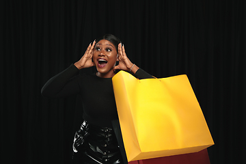 Image showing Young woman in dress shopping on black background