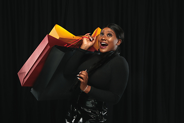 Image showing Young woman in dress shopping on black background