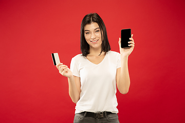 Image showing Caucasian young woman\'s half-length portrait on red background