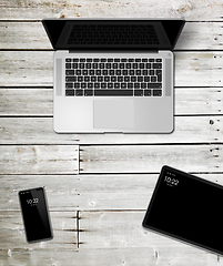 Image showing Laptop, tablet and phone set mockup on a wooden background. 3D r