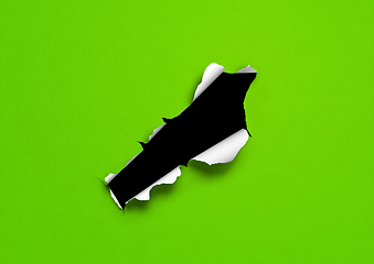 Image showing Green torn paper with black hole