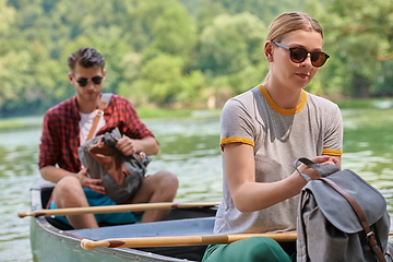 Image showing friends are canoeing in a wild river