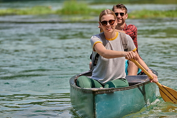 Image showing friends are canoeing in a wild river