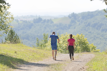 Image showing couple enjoying in a healthy lifestyle while jogging on a country road