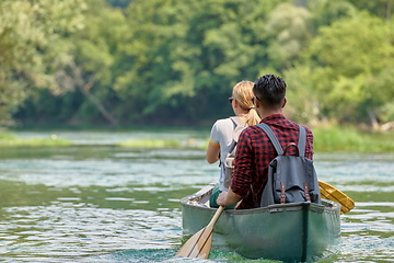 Image showing friends are canoeing in a wild river