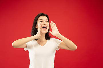 Image showing Caucasian young woman\'s half-length portrait on red background