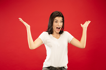 Image showing Caucasian young woman\'s half-length portrait on red background