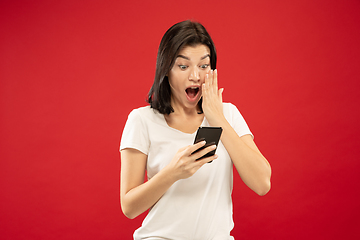 Image showing Caucasian young woman\'s half-length portrait on red background