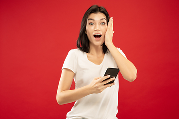 Image showing Caucasian young woman\'s half-length portrait on red background