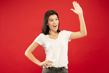 Image showing Caucasian young woman\'s half-length portrait on red background