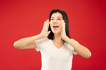 Image showing Caucasian young woman\'s half-length portrait on red background