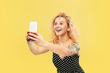 Image showing Caucasian young woman\'s half-length portrait on yellow background