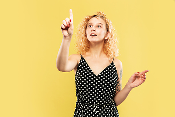 Image showing Caucasian young woman\'s half-length portrait on yellow background