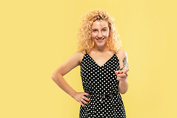 Image showing Caucasian young woman\'s half-length portrait on yellow background