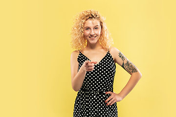 Image showing Caucasian young woman\'s half-length portrait on yellow background