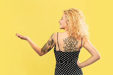 Image showing Caucasian young woman\'s half-length portrait on yellow background