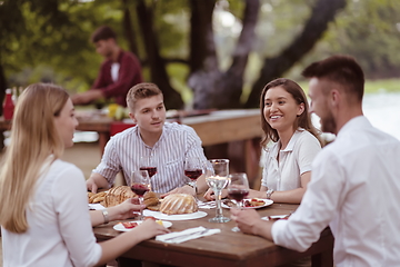 Image showing friends having picnic french dinner party outdoor during summer holiday