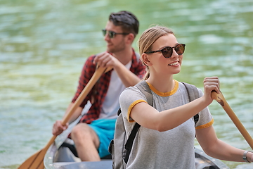 Image showing friends are canoeing in a wild river