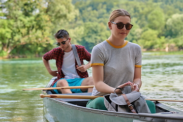 Image showing friends are canoeing in a wild river