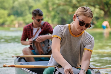 Image showing friends are canoeing in a wild river