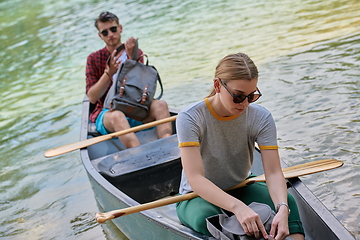 Image showing friends are canoeing in a wild river