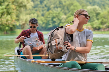 Image showing friends are canoeing in a wild river