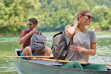 Image showing friends are canoeing in a wild river