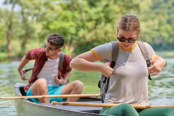 Image showing friends are canoeing in a wild river