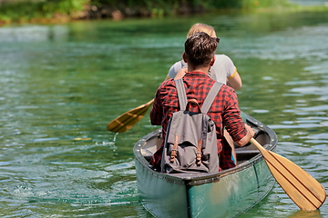 Image showing friends are canoeing in a wild river