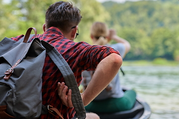 Image showing friends are canoeing in a wild river