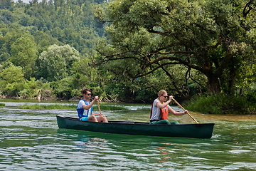 Image showing friends are canoeing in a wild river