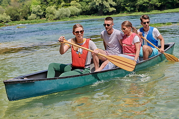 Image showing Group adventurous explorer friends are canoeing in a wild river