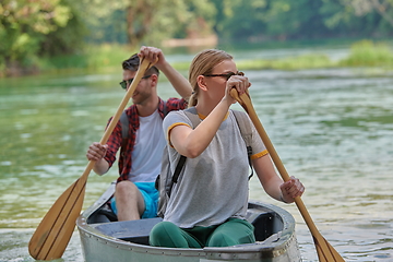 Image showing friends are canoeing in a wild river