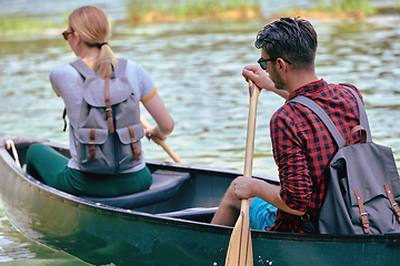 Image showing friends are canoeing in a wild river