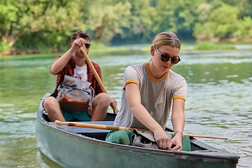 Image showing friends are canoeing in a wild river