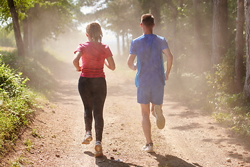 Image showing couple enjoying in a healthy lifestyle while jogging on a country road