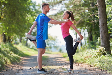 Image showing couple enjoying in a healthy lifestyle warming up and stretching before jogging