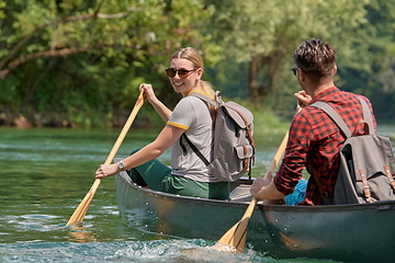 Image showing friends are canoeing in a wild river