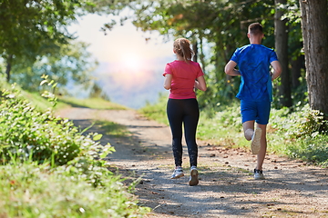 Image showing couple enjoying in a healthy lifestyle while jogging on a country road